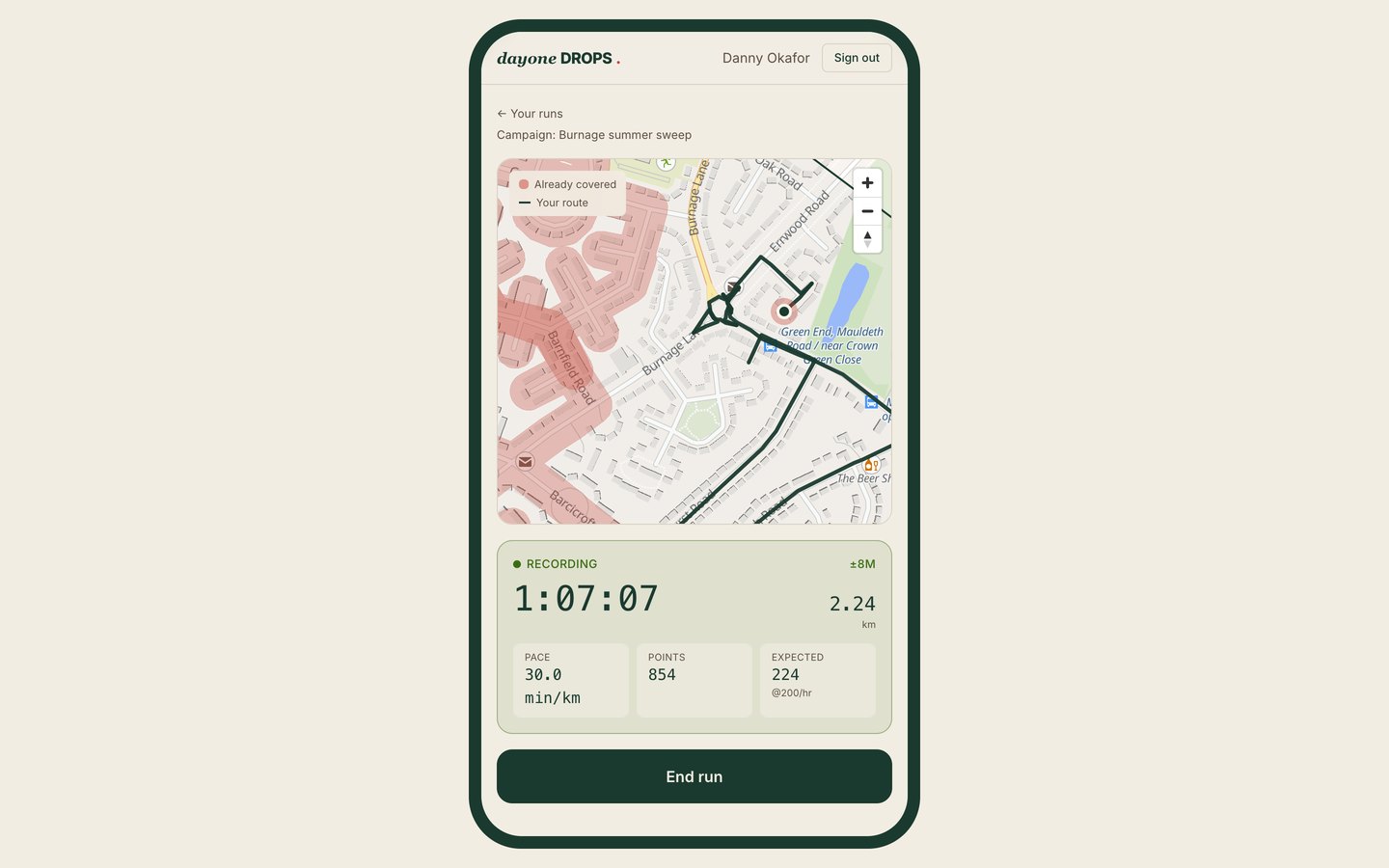 The DayOne Drops live in-run view on a phone, showing the route being walked over the streets already covered, with elapsed time, distance and pace recording as it goes